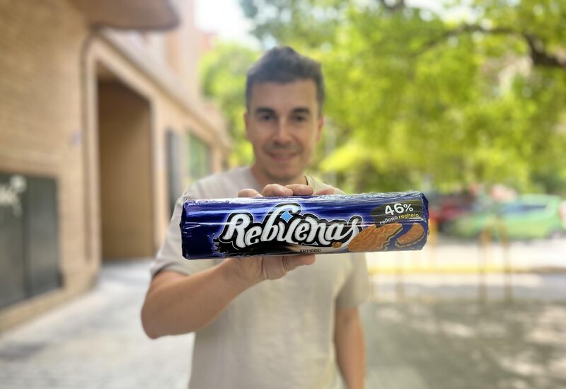 Primer plano de un paquete de galletas Rebuenas con Richard Morla al fondo